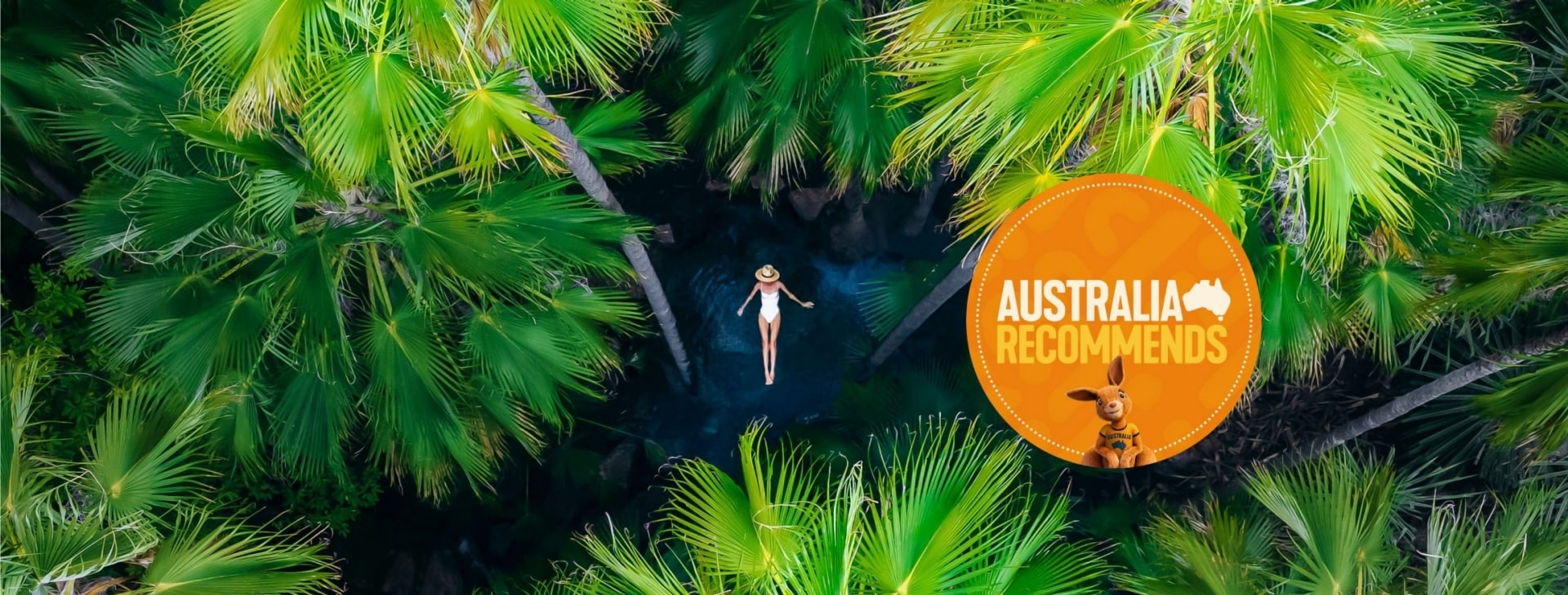 Aerial of woman floating surrounded by palm trees in Zebedee Springs, Kimberley, Western Australia © Tourism Australia