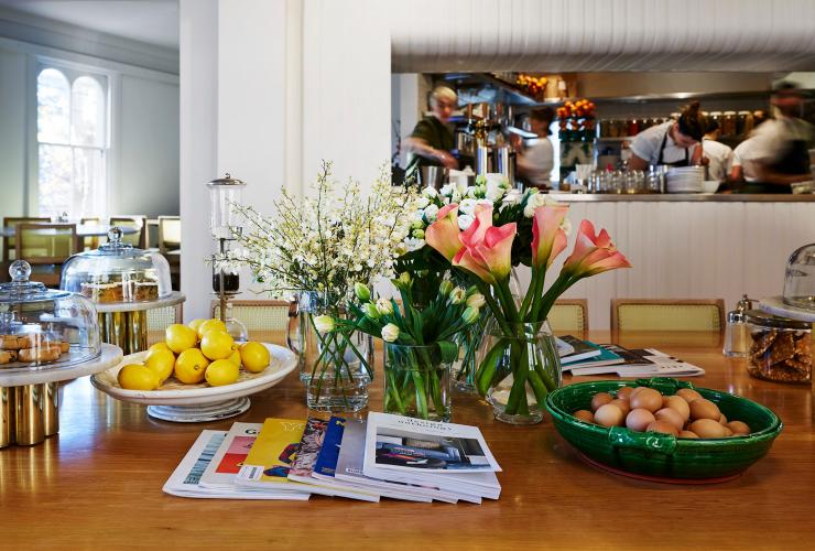 Tisch mit Blumen und Zeitschriften bei Bills, Darlinghurst, Sydney, New South Wales © Megann Evans Photography