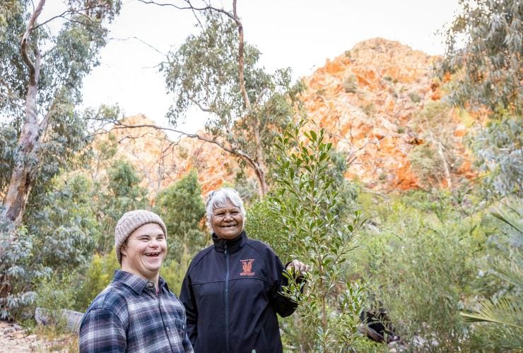 Ein Mann mit Neurodivergenz erkundet Standley Chasm mit einem Reiseführer, West MacDonnell Ranges, Northern Territory © Tourism NT/Helen Orr