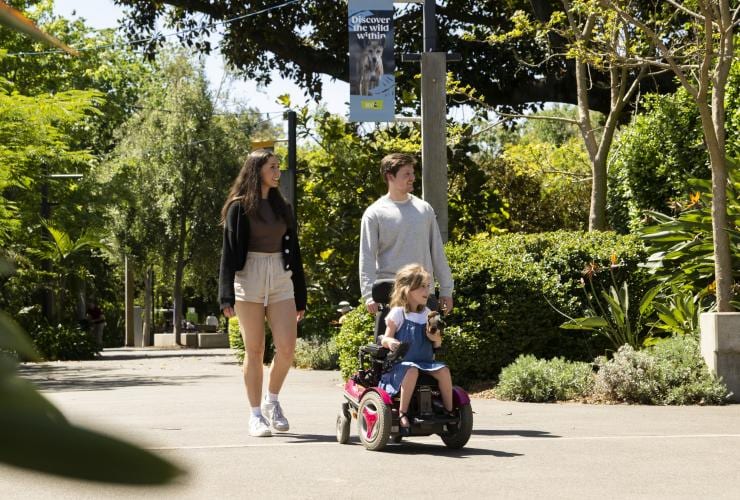 Junges Mädchen im Rollstuhl mit ihren Eltern im Adelaide Zoo, Adelaide, Südaustralien © Tourism Australia