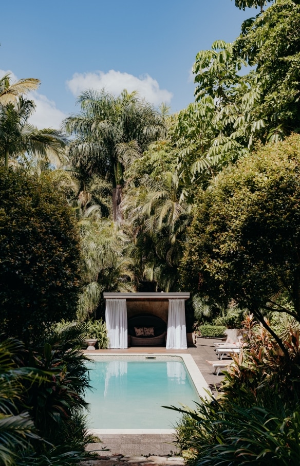 View through trees towards a pool and cabana surrounded by greenery at Gaia Retreat & Spa, Byron Bay, New South Wales © Gaia Retreat & Spa