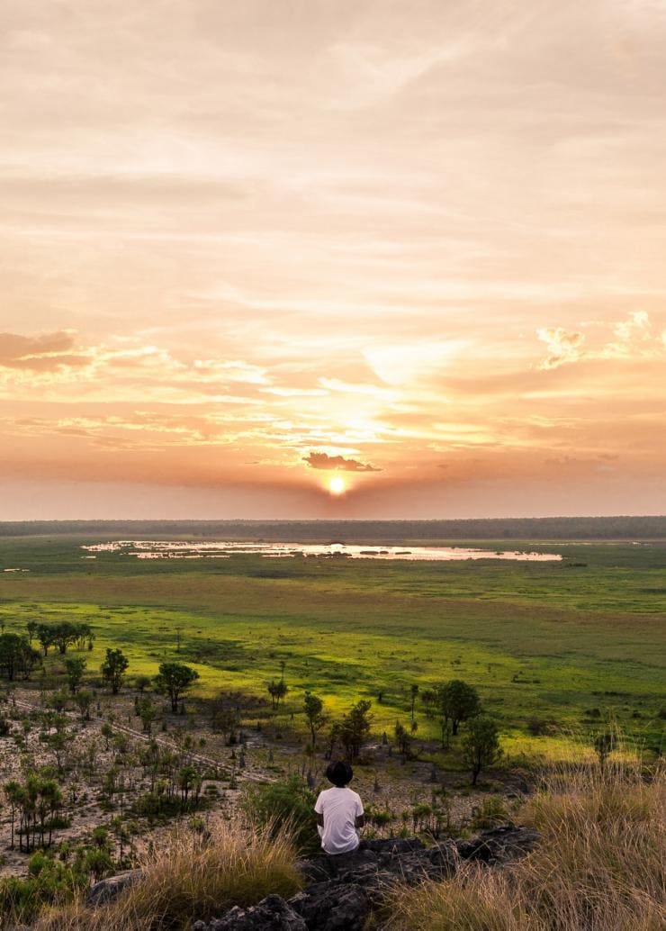 Homme regardant le coucher du soleil sur le Kakadu National Park © Tourism NT