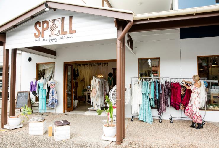 Une femme range des vêtements pour les exposer au Spell & The Gypsy Collective à Byron Bay © Destination NSW