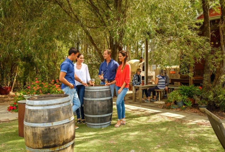 Groupe d'amis dégustant des verres de vin sur la pelouse d'Oranje Tractor Wines © Tourism Western Australia