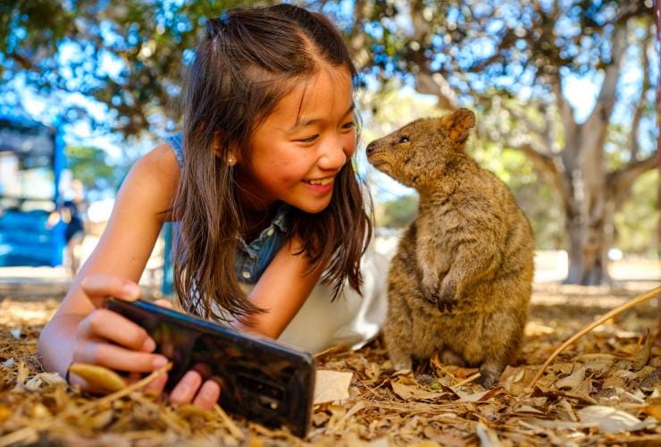 Anak perempuan berfoto dengan Quokka di Rottnest Island di Western Australia © Tourism Australia/Dan Avila Photography