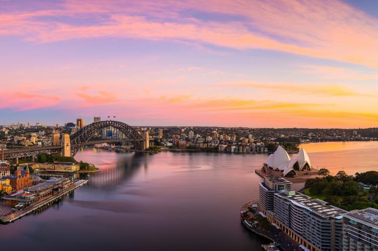 Vista aerea del Sydney Harbour che riflette le tinte blu, rosa e oro del tramonto a Sydney, New South Wales © Destination NSW
