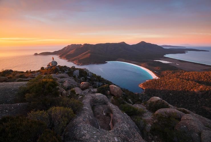 タスマニア州、フレシネ、エイモス山、岩の上に立つ人 © Tourism Australia