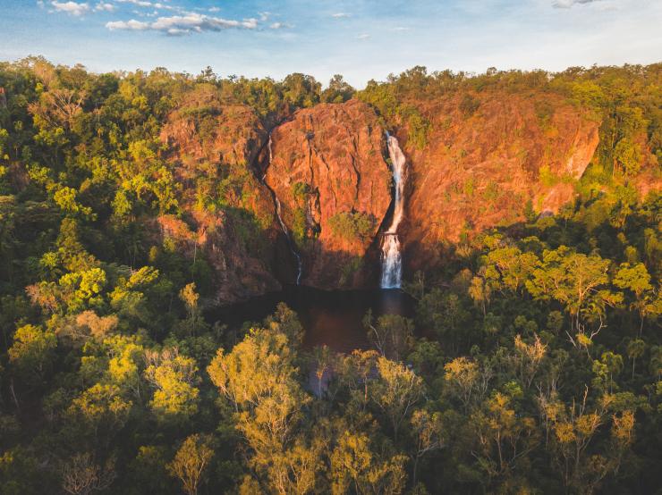 An aerial view of Wangi Falls against a red rock cliff in Litchfield National Park © Tourism NT/Dan Moore