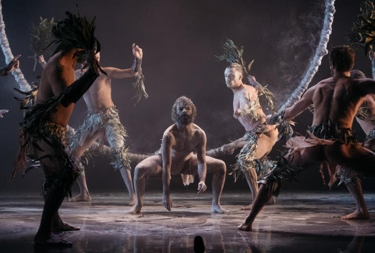 Gruppe von First Nations-Tänzern, geschmückt mit Eukalyptuszweigen, bei einer Vorstellung auf der Bühne des Sydney Opera House © Daniel Boud