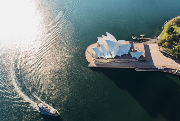 Luftaufnahme des Sydney Opera House mit einem Boot mit Heckwelle im umliegenden Wasser, Sydney, New South Wales © Hamilton Lund