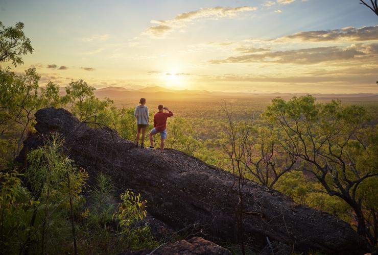 Ein Mann und eine Frau stehen auf einem Felsen mit Blick auf einen Wald bei Sonnenaufgang an der Mt Mulligan Lodge, Mt Mulligan, Queensland © Tourism and Events Queensland