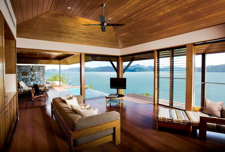 Interior akomodasi dengan lantai kayu, kolam renang pribadi, dan jendela setinggi langit-langit yang menghadap ke samudra di qualia, Hamilton Island, Queensland © Hamilton Island