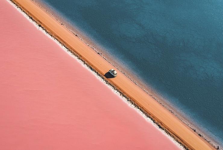 에어 페닌슐라에 위치한 핑크빛 맥도넬 호수와 그린 호수 사이에 난 비포장 도로를 따라 주행하고 있는 밴의 모습을 공중에서 촬영한 모습, 남호주 © 린든 오키프(Lyndon O'Keefe)