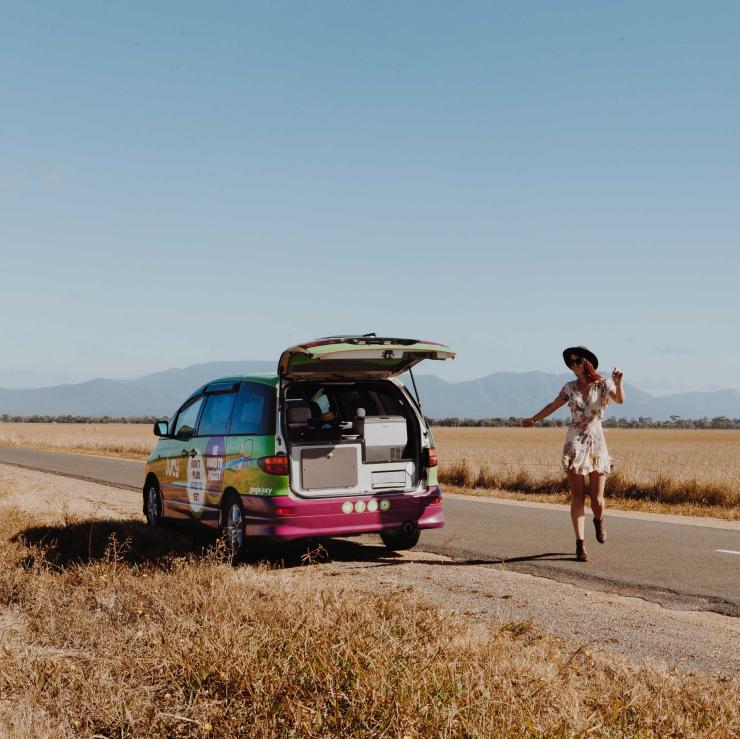 Mädchen steht neben einem JUCY-Campervan am Straßenrand der Great Ocean Road © Jucy, Katie Purling