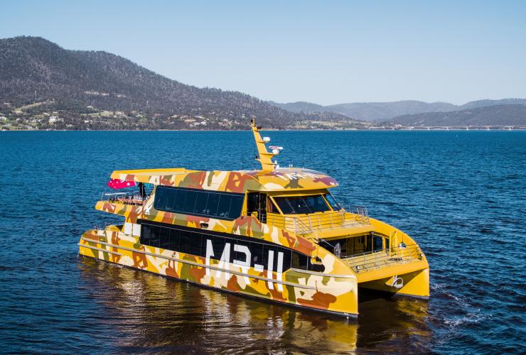 Aerial of a yellow camouflage painted MR-II ferry to the Museum of Old and New Art, Hobart, Tasmania © MONA/Stu Gibson