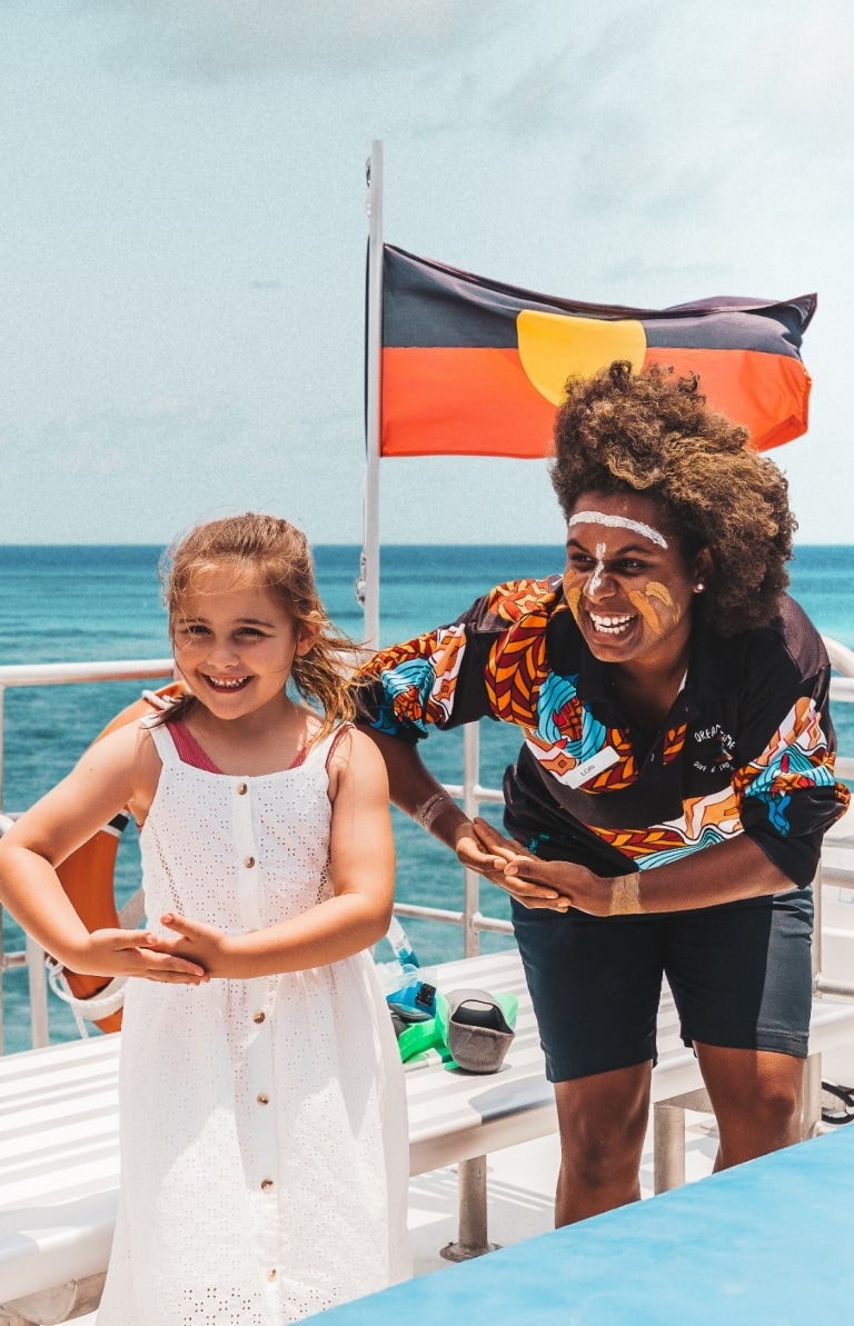 Kinder, die auf einer Tour mit Dreamtime Dive and Snorkel mit einem Aboriginal Guide für ein Foto posieren