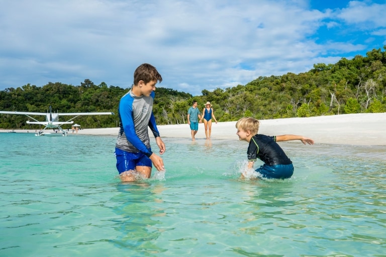 Zwei Kinder planschen im Wasser am Whitehaven Beach in Queensland © Tourism and Events Queensland