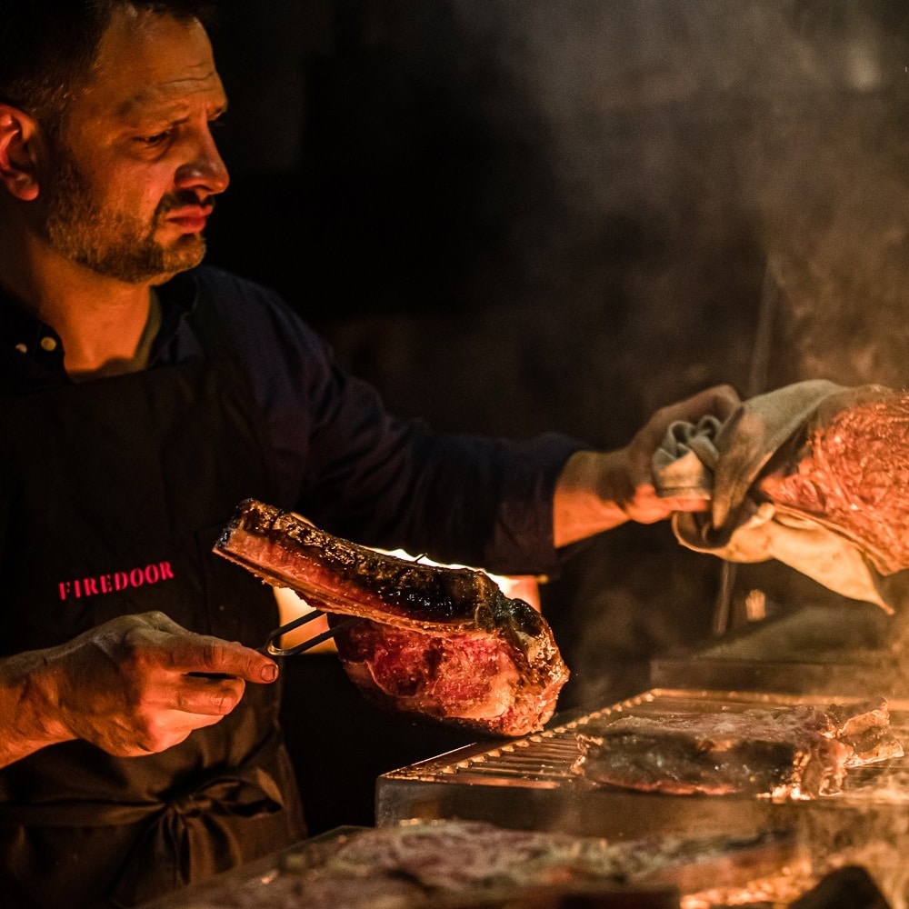 Koch beim Zubereiten von Fleisch im Restaurant Firedoor in Sydney © Nikki To