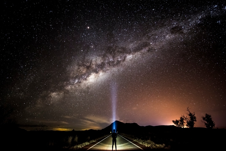 Sterngucker mit Stirnlampe, der zur Milchstraße aufschaut © Tourism and Events Queensland/Sean Scott