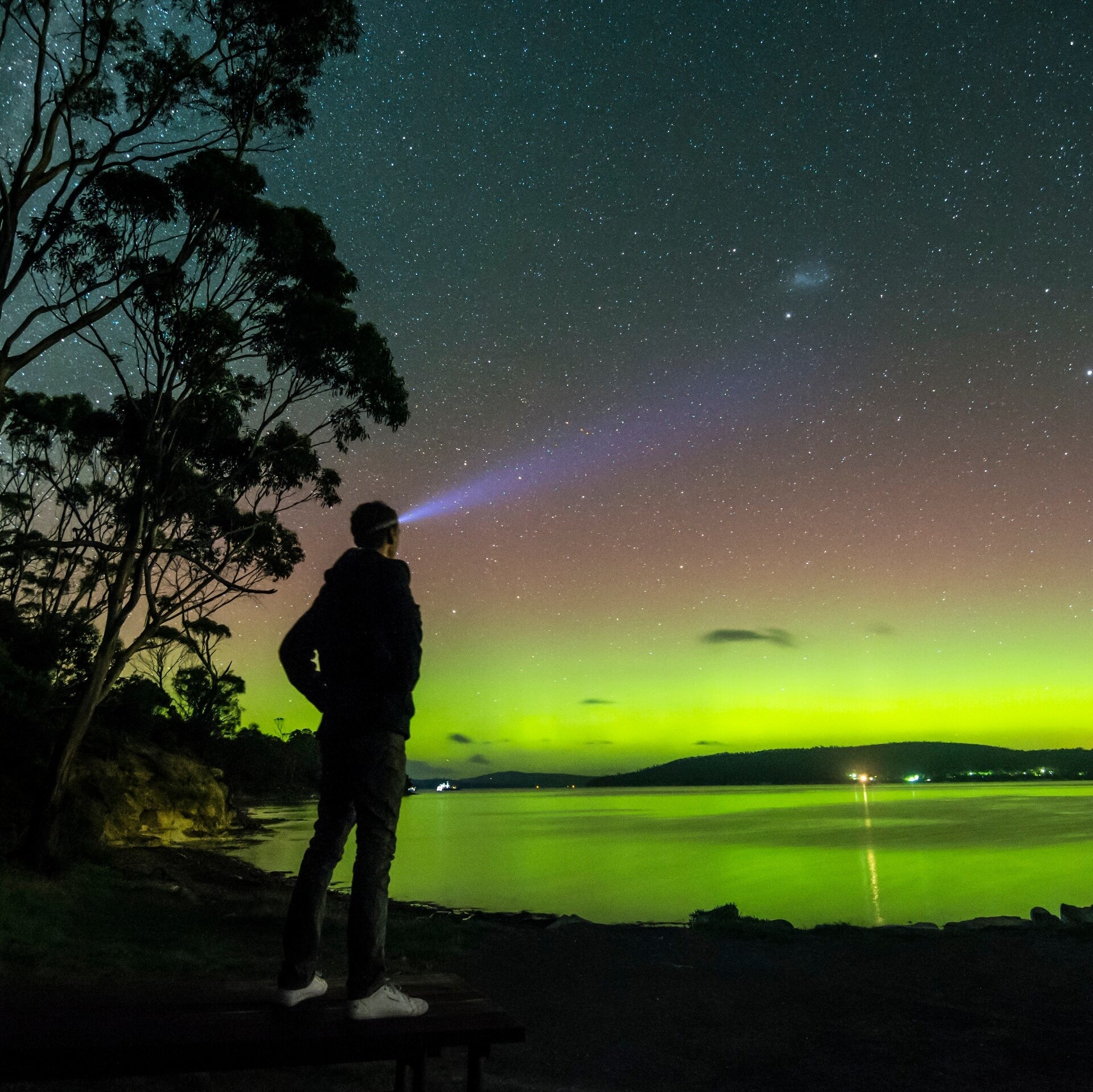 Mann mit Stirnlampe bestaunt die Aurora Australis bei Howden © Simon Kruit