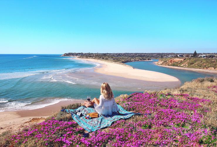 Junge Frau genießt Picknick zwischen Wildblumen auf der Fleurieu Peninsula © Elise Cook