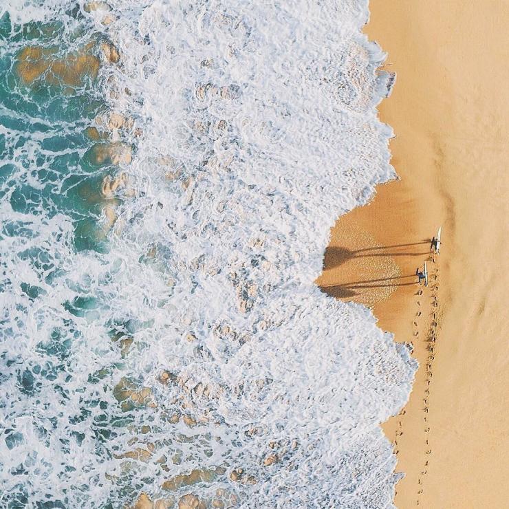 Aerial overlooking surfers walking along Palm Beach, Sydney © Adam Krowitz