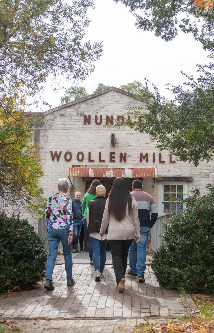 Visitors walk toward the heritage facade of the Nundle Woolen Mill, New England, New South Wales © Tourism Australia