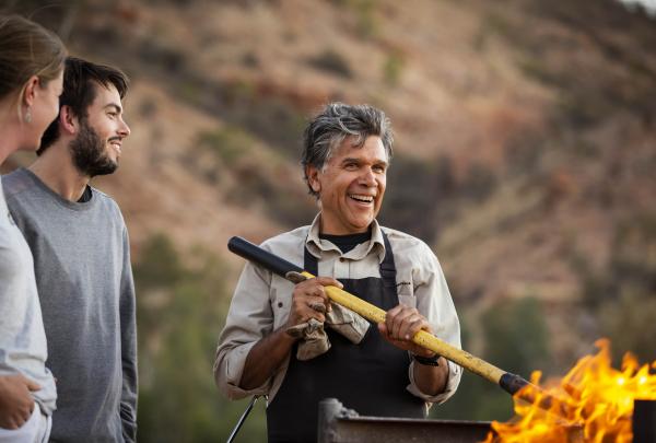 Chef cooks for guests over a bush barbecue © Tourism Australia