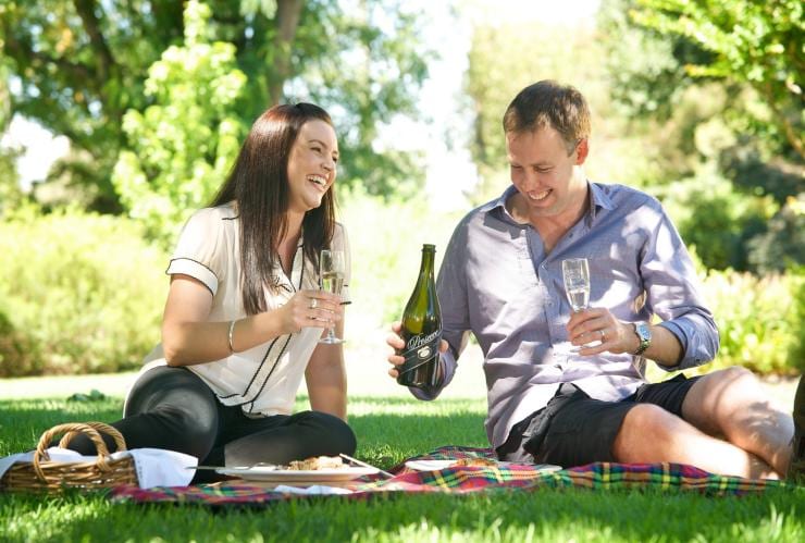 Couple enjoying prosecco at a picnic at Brown Brothers Winery © Visit Victoria