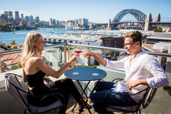 Couple enjoying drinks on the rooftop at Henry Deane in Sydney © Destination NSW