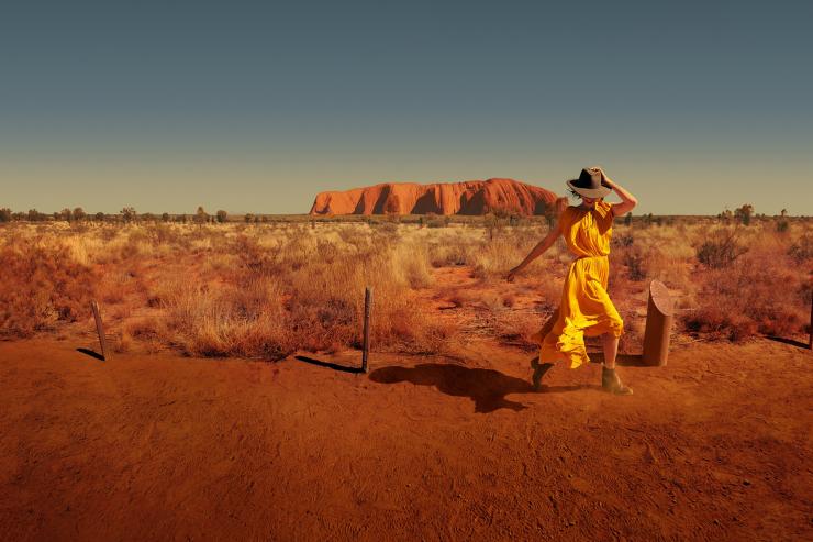 Woman walks around the base of Uluru in Uluru-Kata Tjuta National Park in the Northern Territory © Tourism Australia