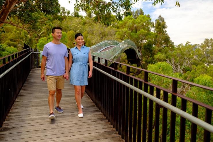 A man and woman wandering along an elevated boardwalk through the treetops in Kings Park and Botanic Garden, Perth, Western Australia © Tourism Western Australia A man and woman wandering along an elevated boardwalk through the treetops in Kings Park and Botanic Garden, Perth, Western Australia © Tourism Western Australia