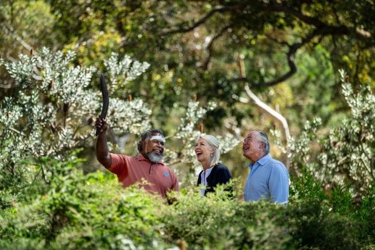 A couple wandering through greenery with an Aboriginal guide in traditional body paint during an experience with Go Cultural Aboriginal Tours and Experiences, Perth, Western Australia © Tourism Australia A couple wandering through greenery with an Aboriginal guide in traditional body paint during an experience with Go Cultural Aboriginal Tours and Experiences, Perth, Western Australia © Tourism Australia