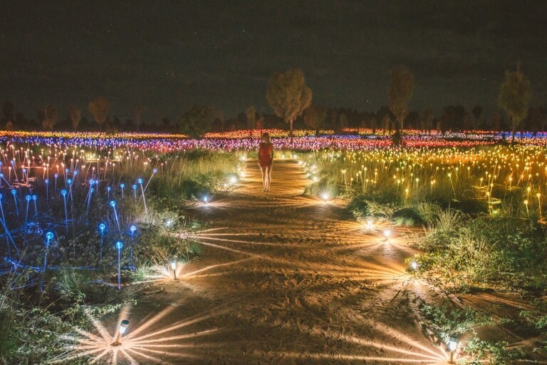A visitor walking through the Field of Light art installation © Tourism NT/Mitchell Cox