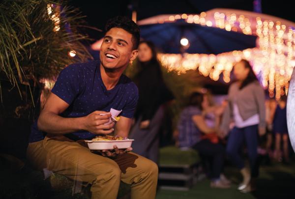 Man eating food at Eat Street Markets in Brisbane © Tourism and Events Queensland