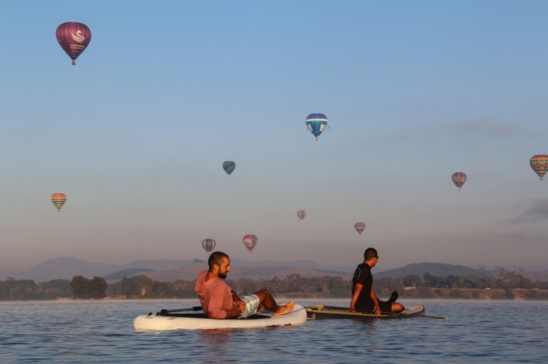 Two men resting on stand up paddleboards on Lake Burley Griffin, Canberra, Australian Capital Territory © Visit Canberra