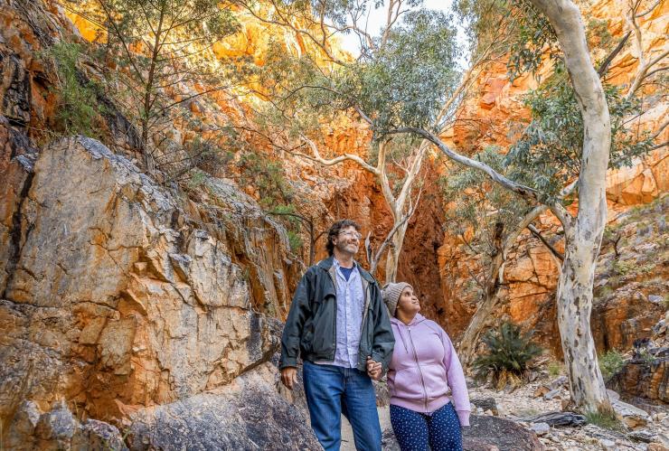 Woman with a neurological disability and a man gazing upwards at Standley Chasm, West MacDonnell Ranges, Northern Territory © Tourism NT/Helen Orr