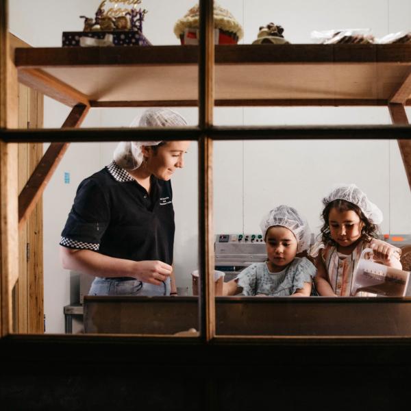Young girls enjoying a chocolate making lesson at Junee Licorice & Chocolate Factory © Destination NSW