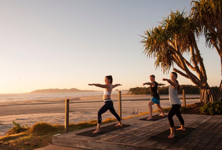 People doing sunrise yoga by the beach at Elements of Byron Bay Resort & Spa in Byron Bay © Destination NSW