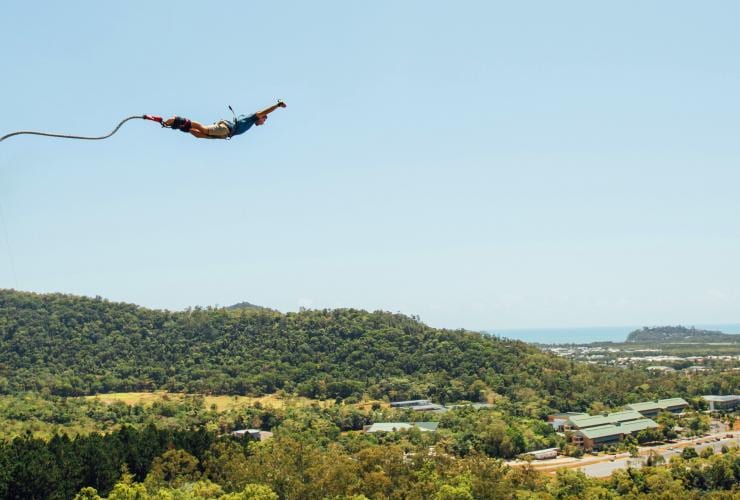 A person jumping mid air over a lush rainforest while attached to a rope with AJ Hackett Bungy Jumping, Cairns, Queensland © Tourism Tropical North Queensland