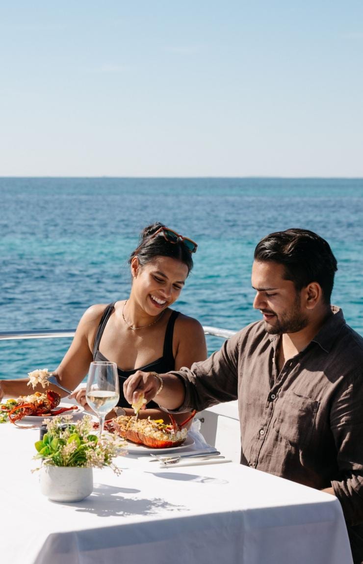 A couple dining on seafood on a boat, Rottnest Cruises, Rottnest Island, Western Australia © Tourism Australia