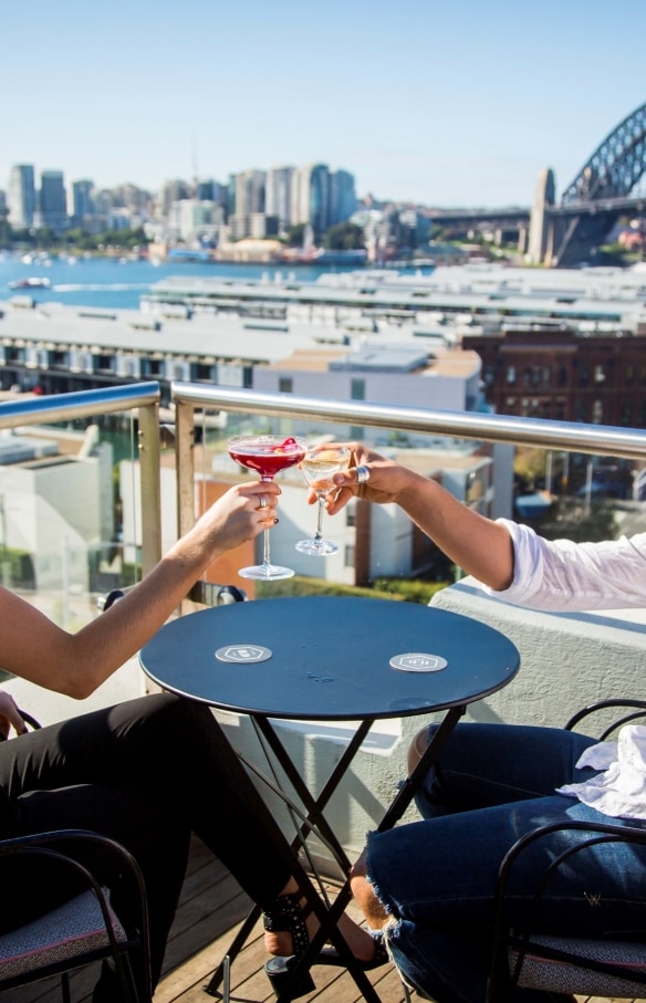 Couple enjoying drinks on the rooftop at Henry Deane in Sydney © Destination NSW