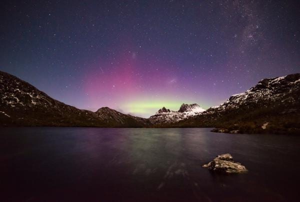 Man with head torch looks up at the night sky filled with bright stars over the dark sky park in the Warrumbungles © Destination NSW