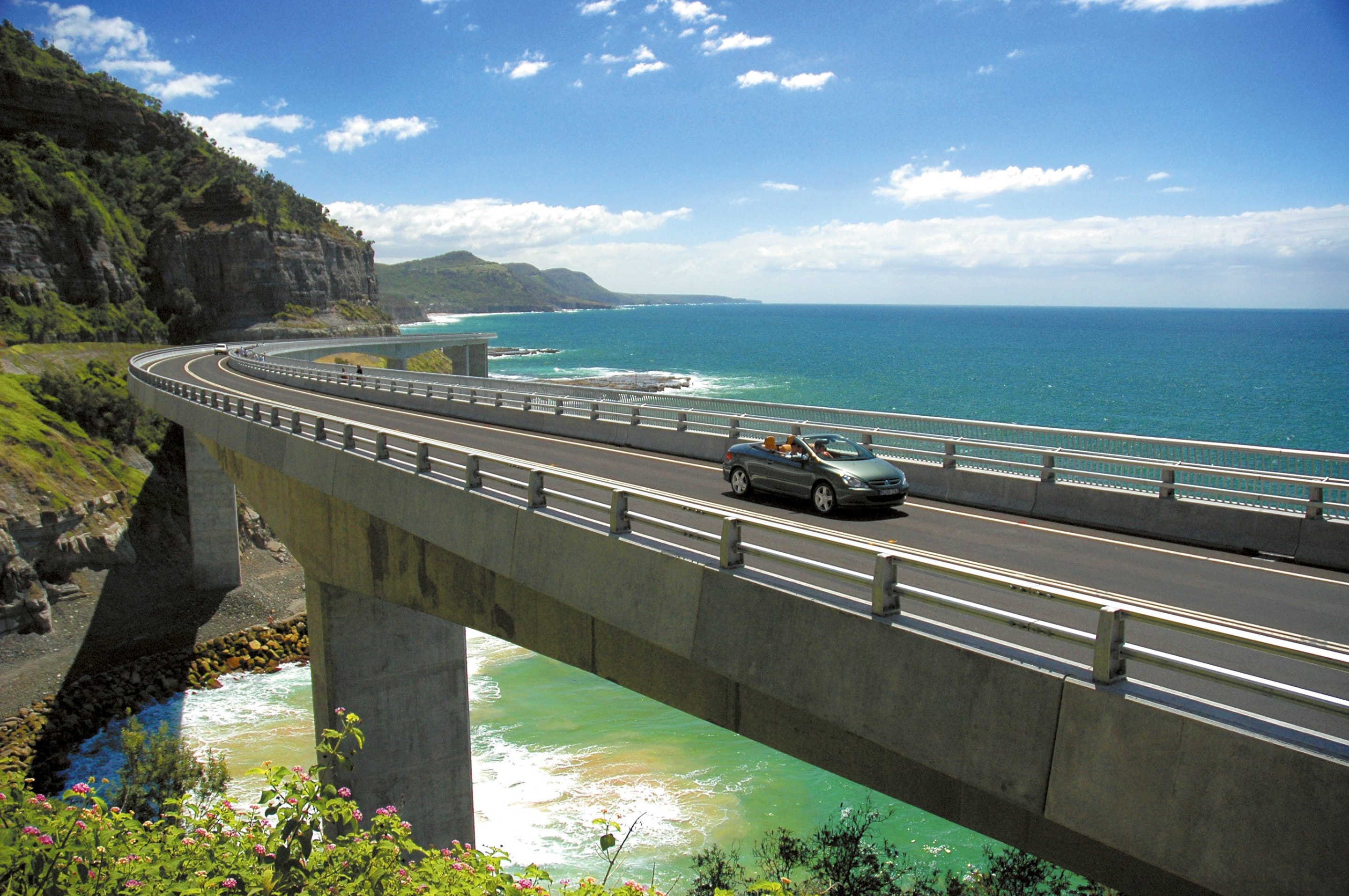 Car driving along the Sea Cliff Bridge in Clifton © Destination NSW
