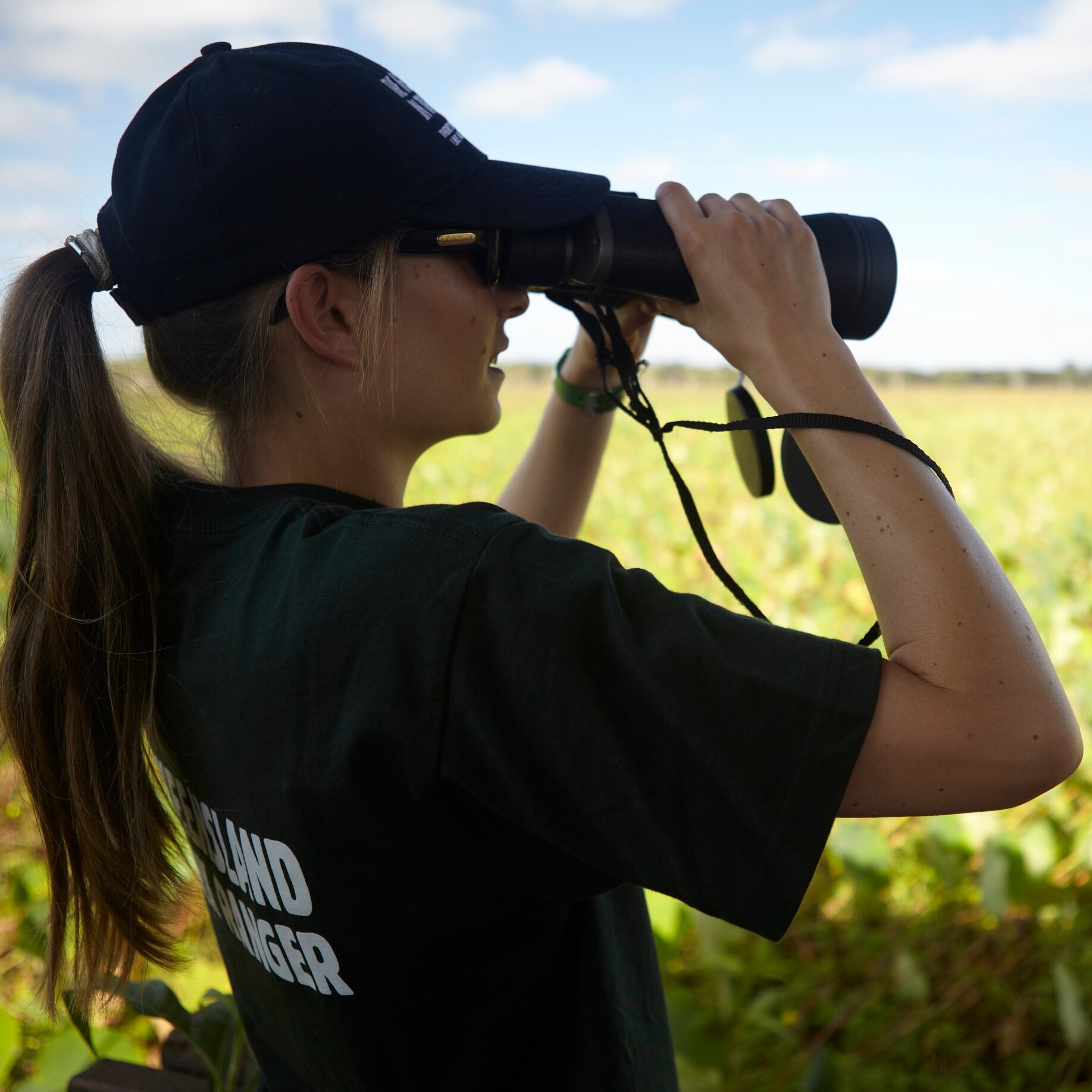 Ranger looks through binoculars at White Lily Lagoon in Rinyirru (Lakefield) National Park © Tourism Australia