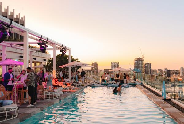 People enjoying a rooftop bar with a pool during sunset, Lina Rooftop Bar, Brisbane, Queensland © Brisbane Economic Development Agency