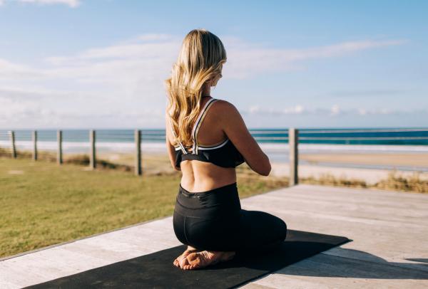 Woman doing yoga by the beach at Elements of Byron Bay © Destination NSW