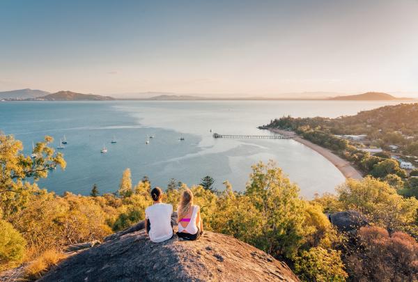 Two girls sat on Hawkins Point looking out to sea © Tourism and Events Queensland