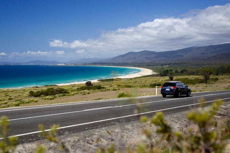 Car driving on road next to the ocean in Lagoons Beach Conservation Area © Pete Harmsen/Tourism Tasmania
