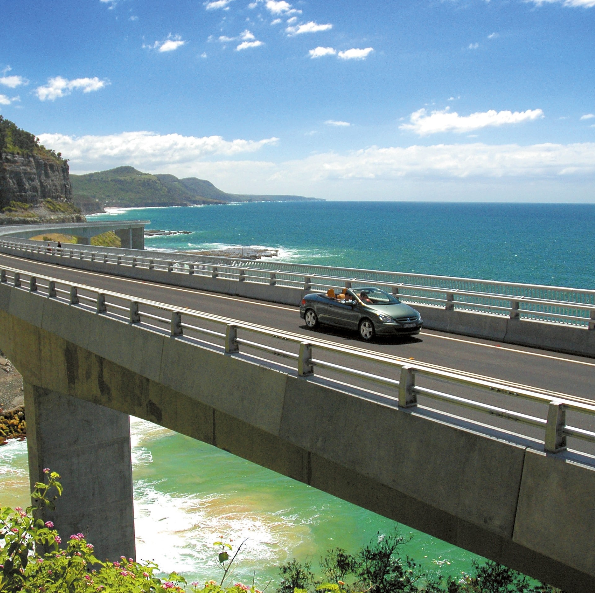 Car driving along the Sea Cliff Bridge in Clifton © Destination NSW